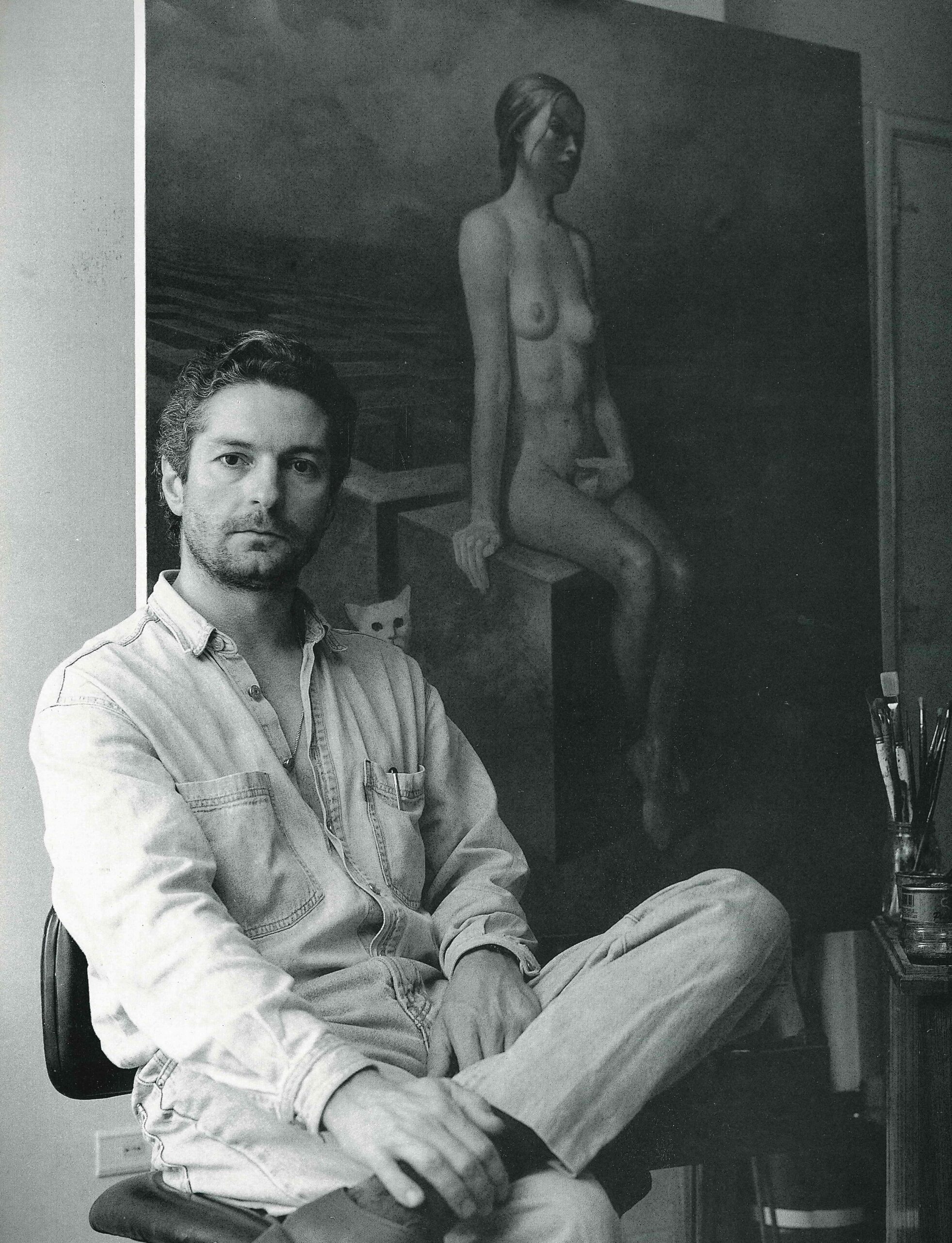 Artist Alberto Pancorbo Sitting In Front Of A Painting Of A Woman