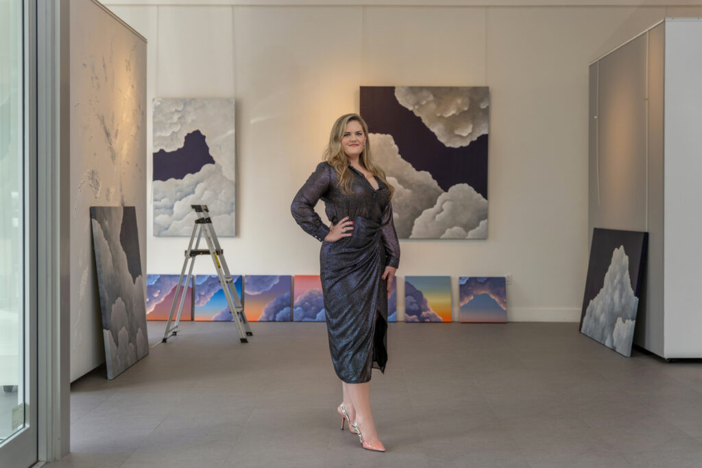 Artist Liv Dockerty Woman In A Black Dress Posing In Art Gallery