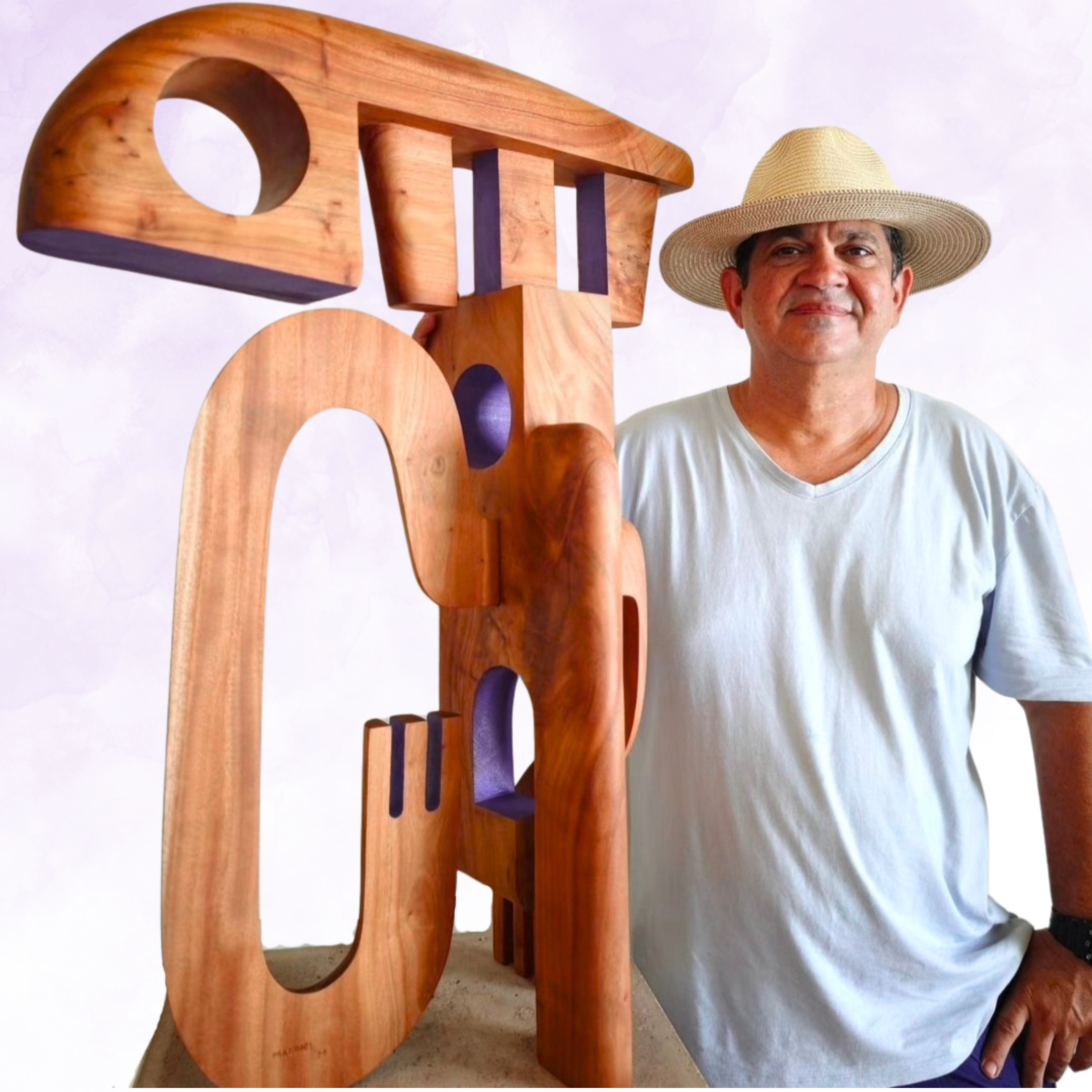 Artist Magdiel Garcia Almanza Wearing A Straw Hat And Standing Next To One His Wooden Sculptures